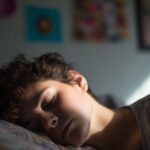 Osoba spava u polumraku obasjana jutarnjim svetlom